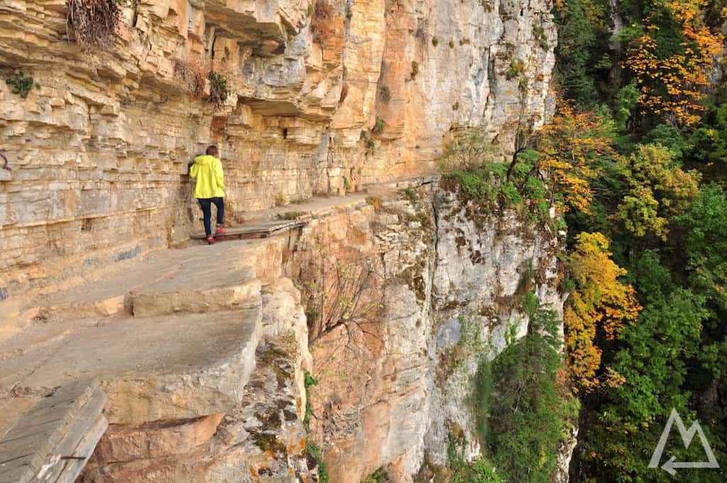 hiking trail man made cut into overhanging walls in Greece