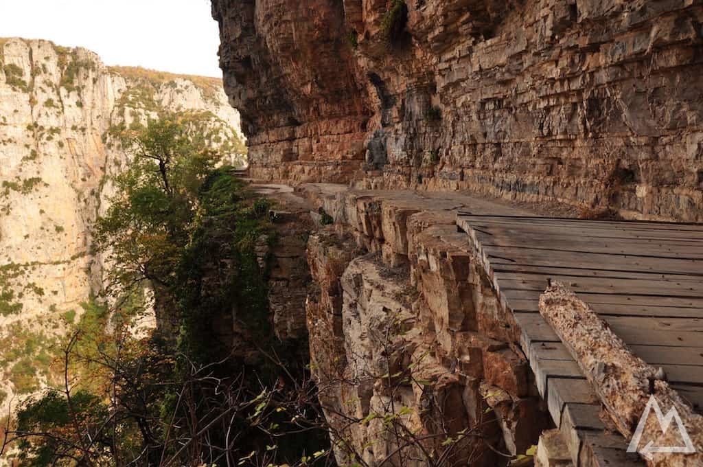 hiking trail man made cut into overhanging walls in Greece