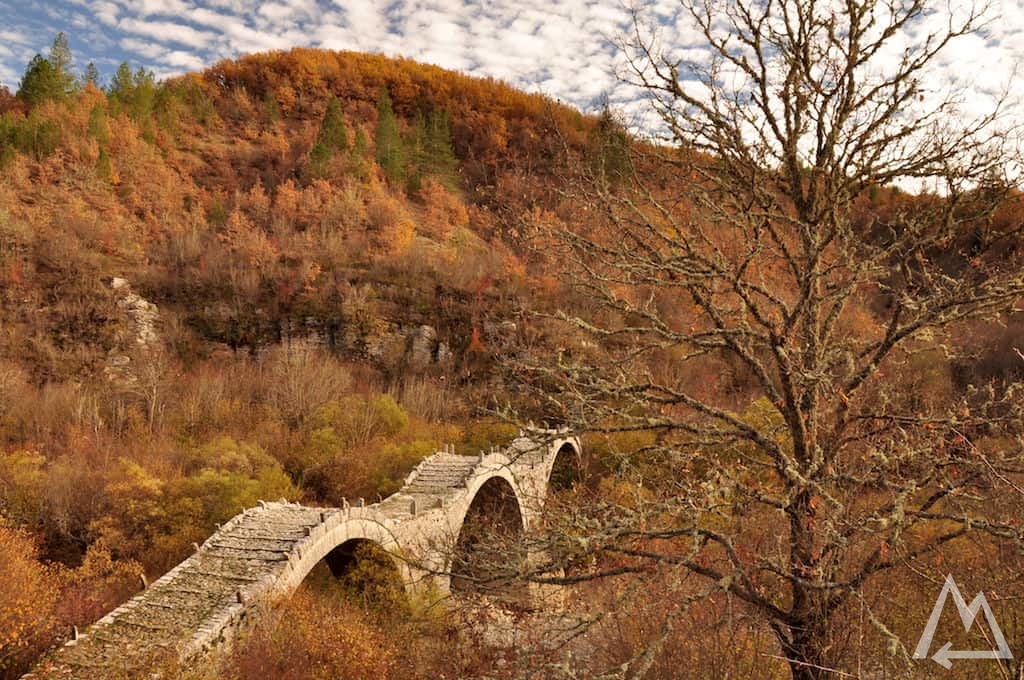 Stone bridge in autumn forest in Greece